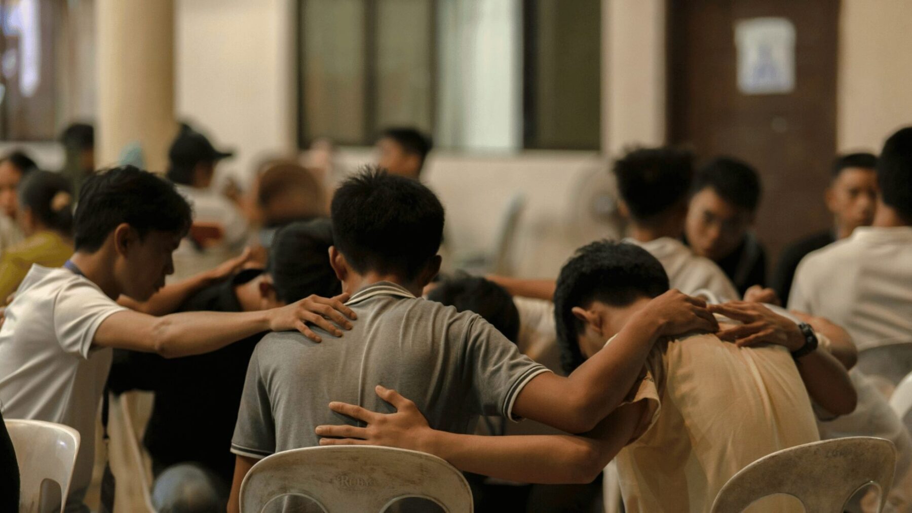 Young people praying in a circle